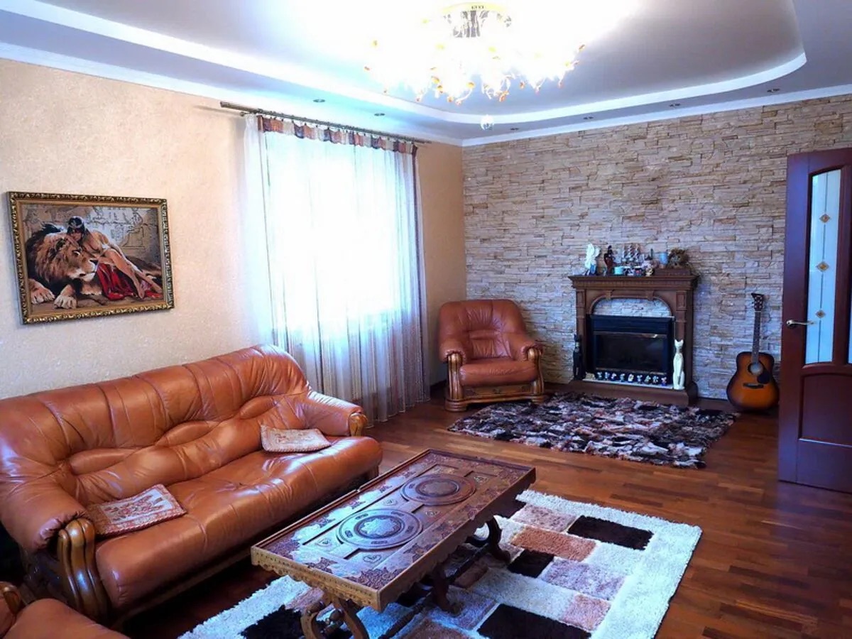 Гостиная с камином, статуэткой кота и картиной со львом.