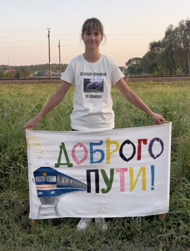 Пинчанка Саша с плакатом «Доброго пути!»